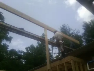 Carpenter setting a ridge beam over a new addition frame — Ice Dam Removal by Roofing Brothers in Weir