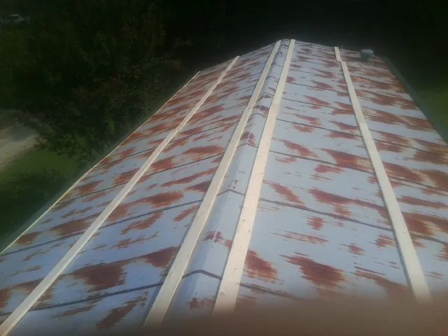 Rusted metal roof panels with new wood purlins before replacement — Storm Damage Roof Repair in Weir by Roofing Brothers