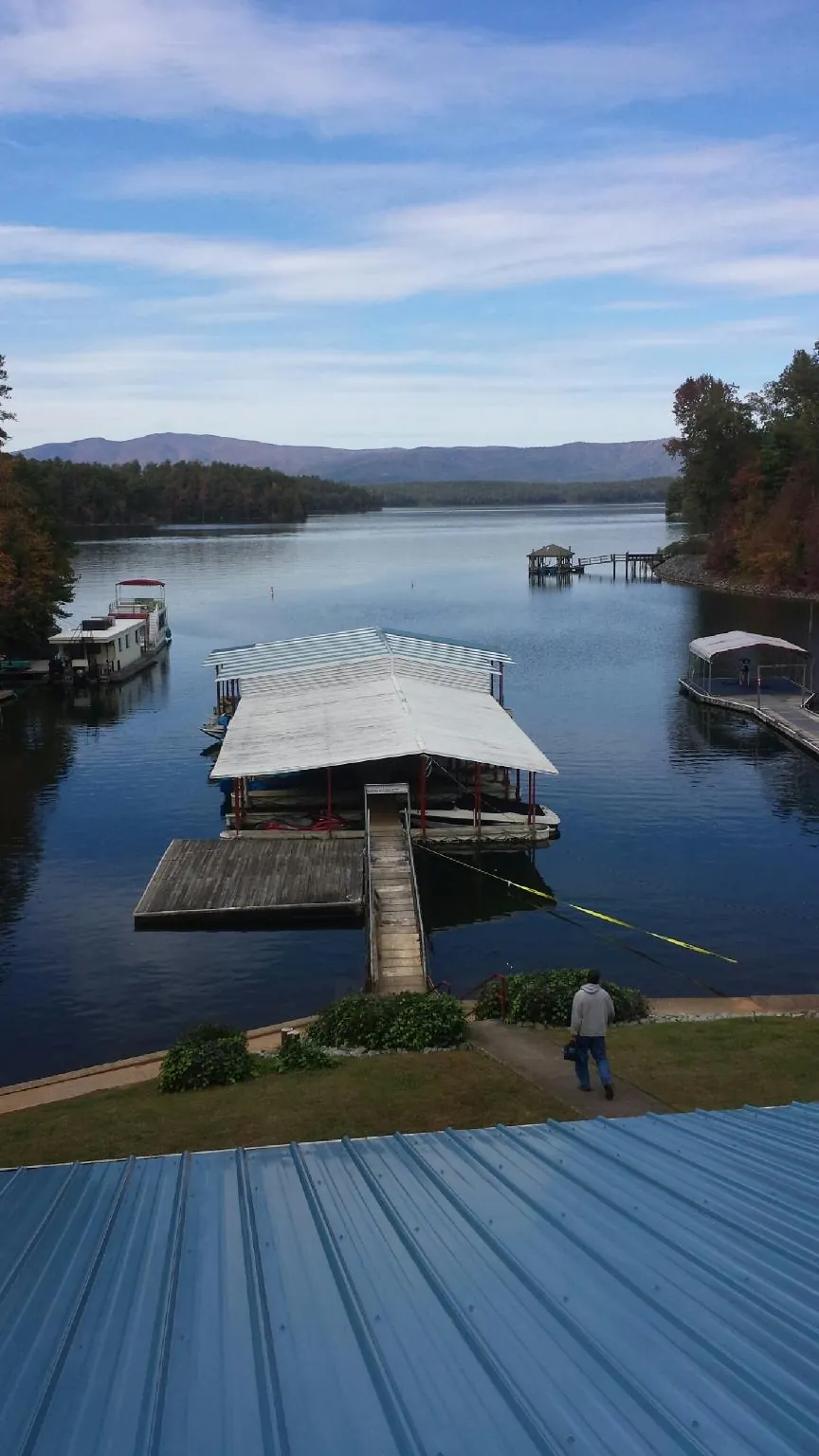 View across a lake from a newly installed blue metal roof in Weir