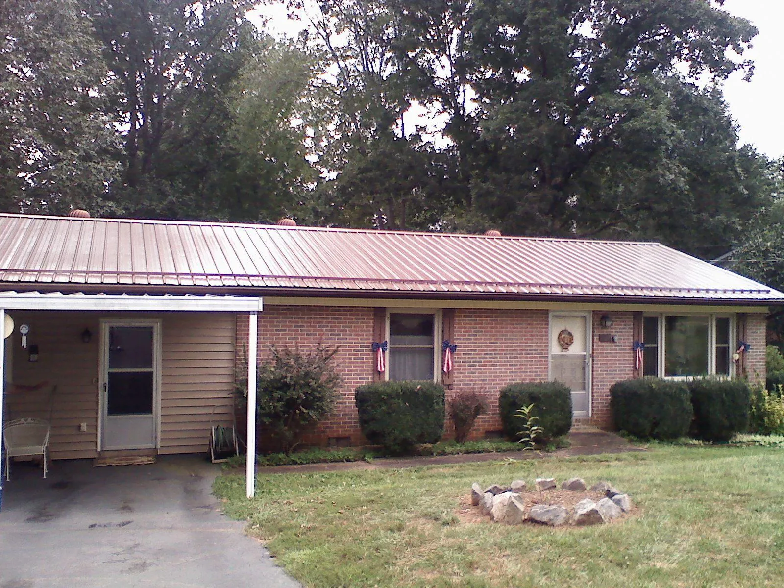 Bronze metal roof and carport on a brick ranch home — Roof Repair work by our crew in Weir